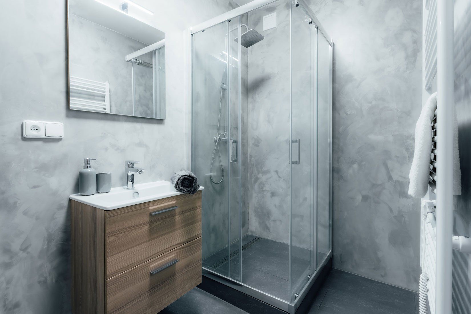 Salle de bain avec murs gris à effet peinture et une douche avec vitres