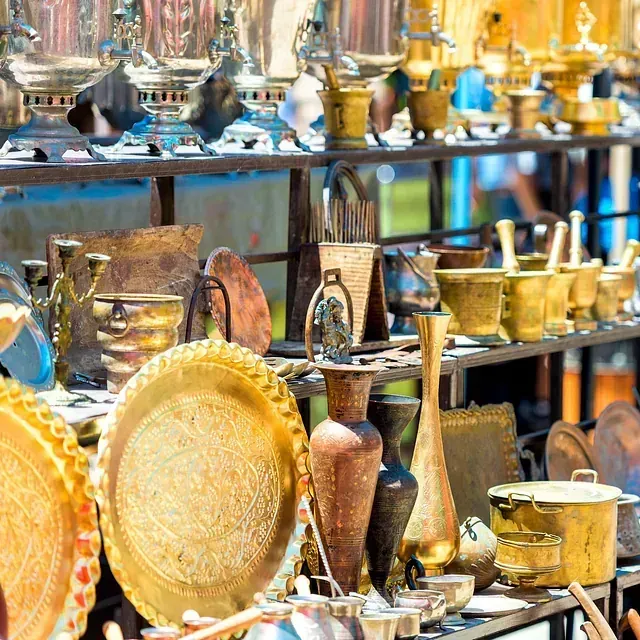 Una exhibición de platos, jarrones, ollas y sartenes sobre una mesa.