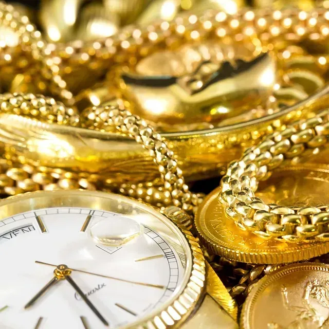 Un primer plano de un reloj rodeado de joyas de oro.