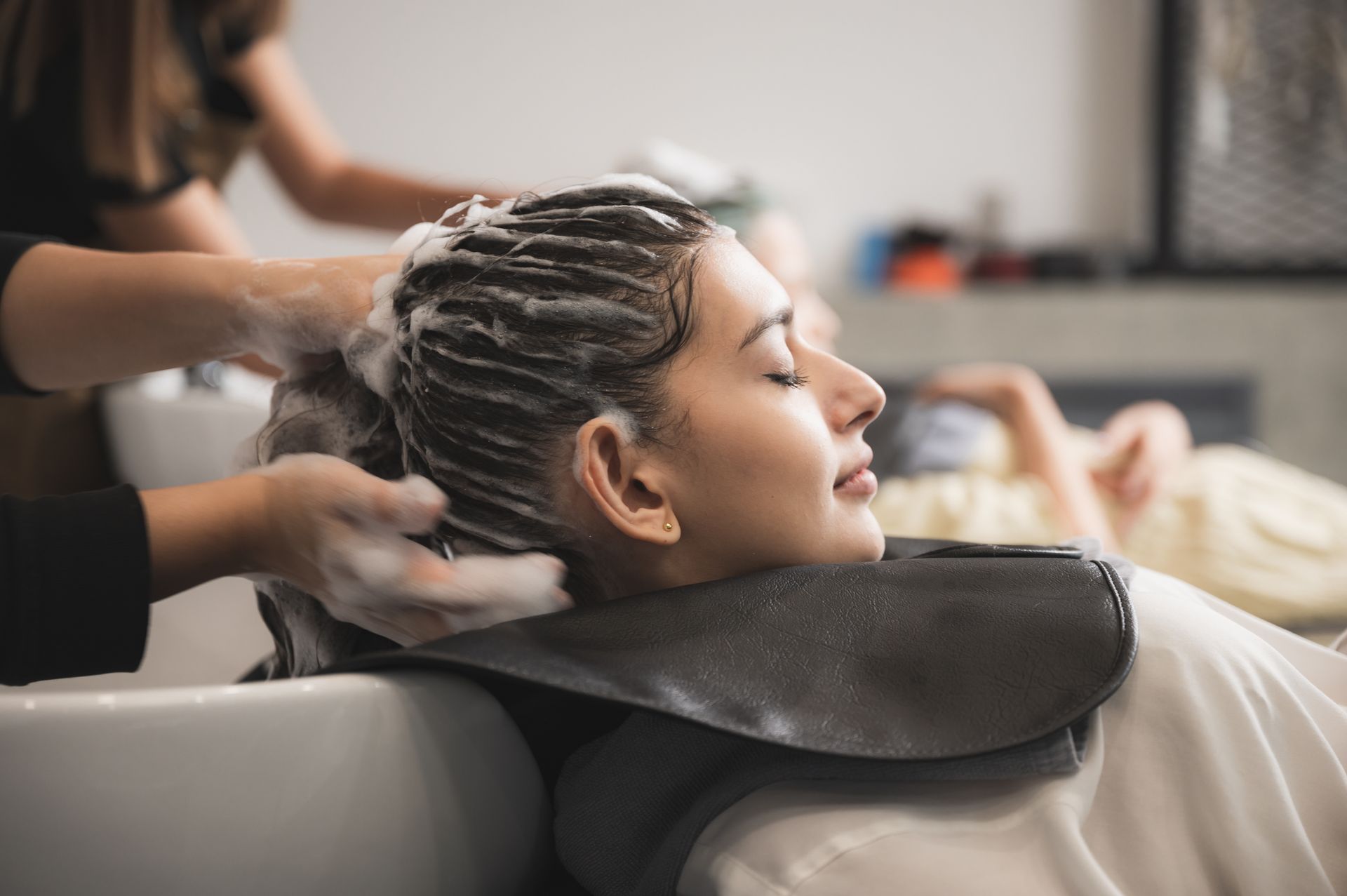 Mitarbeiterin von Hairdesign Michelangelo wäscht Kundin die Haare