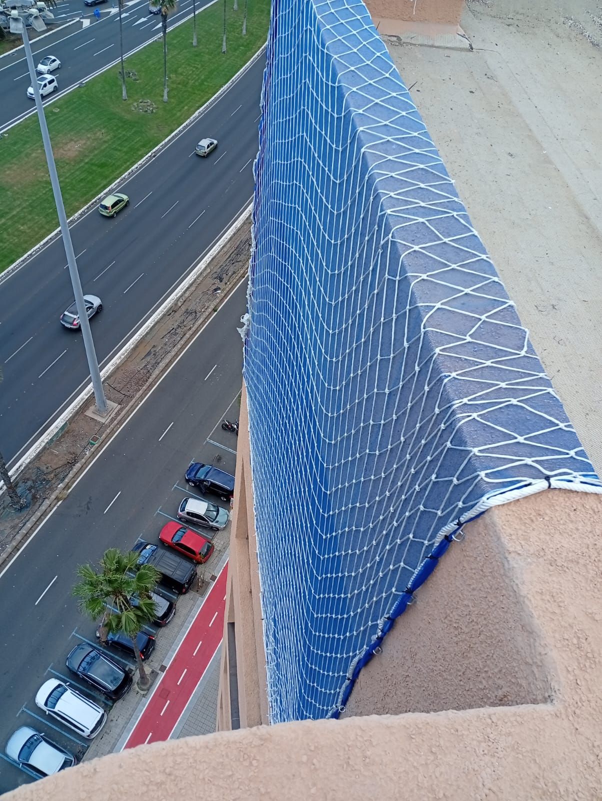 Una vista aérea de un edificio con autos estacionados frente a él.