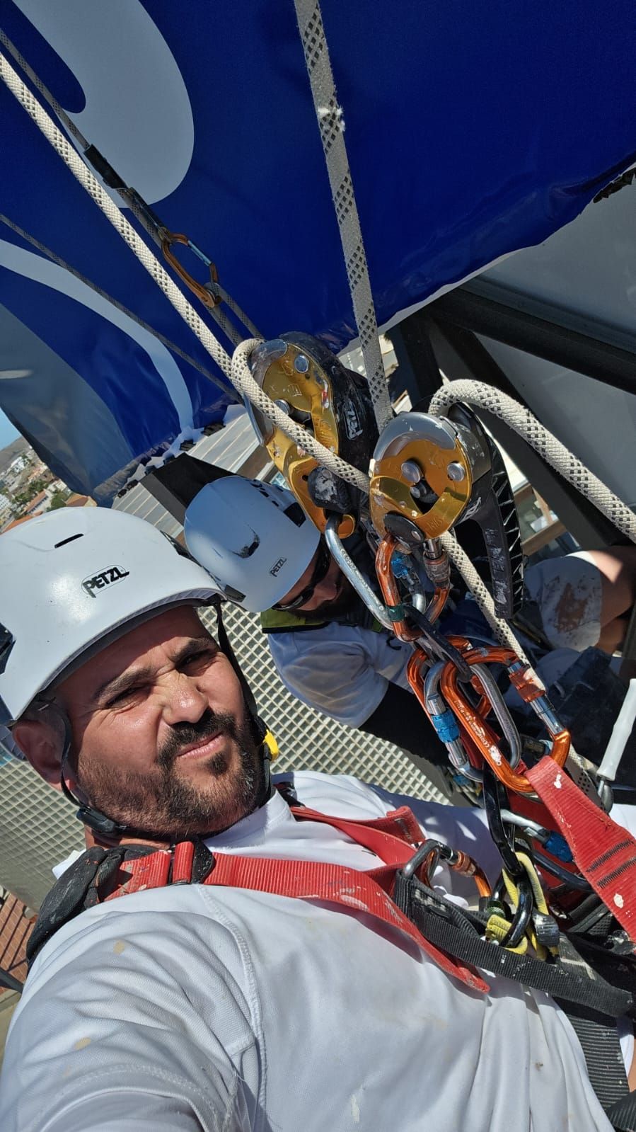 Un hombre que lleva casco y arnés de seguridad se está tomando una selfie.