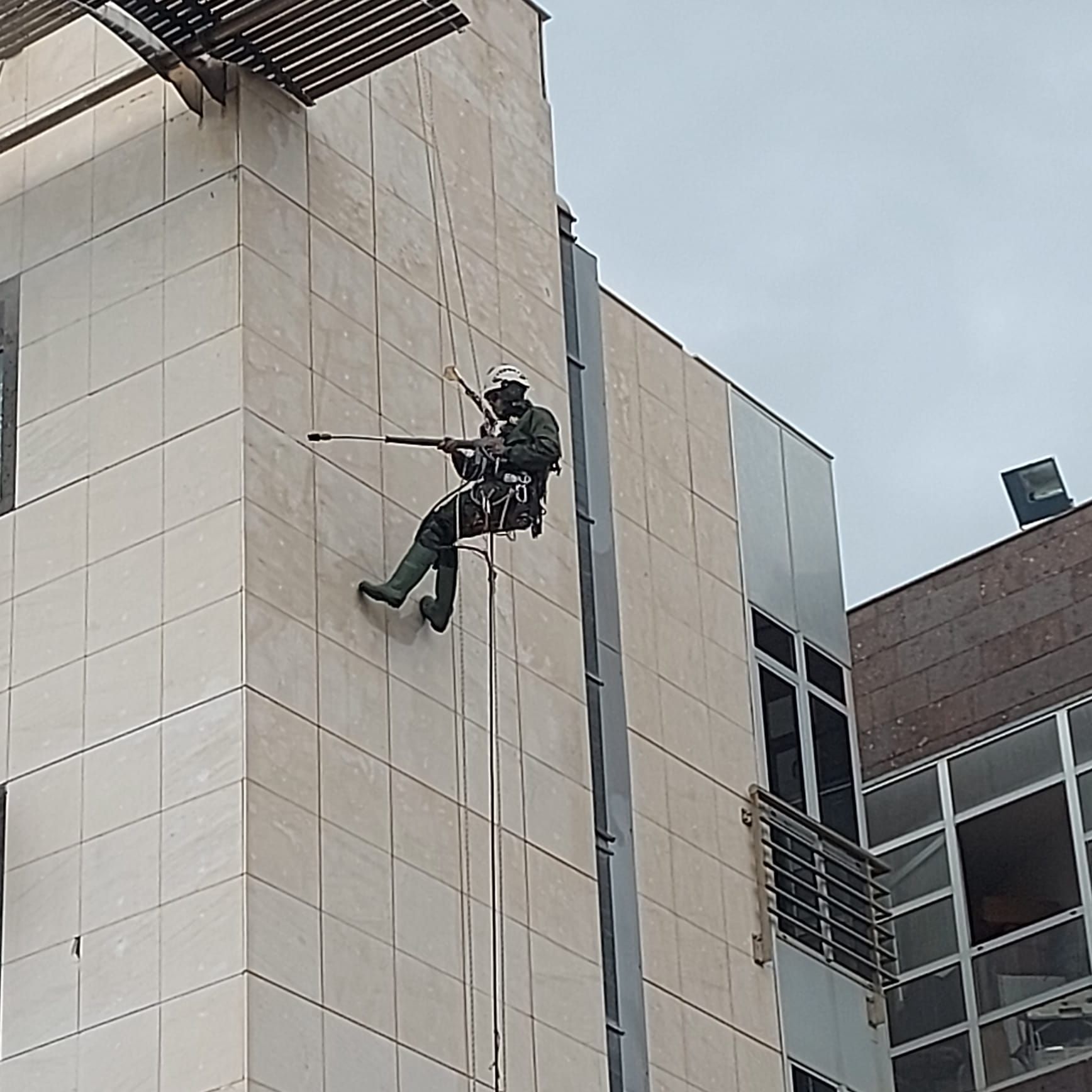 Un hombre está subiendo por el costado de un edificio.