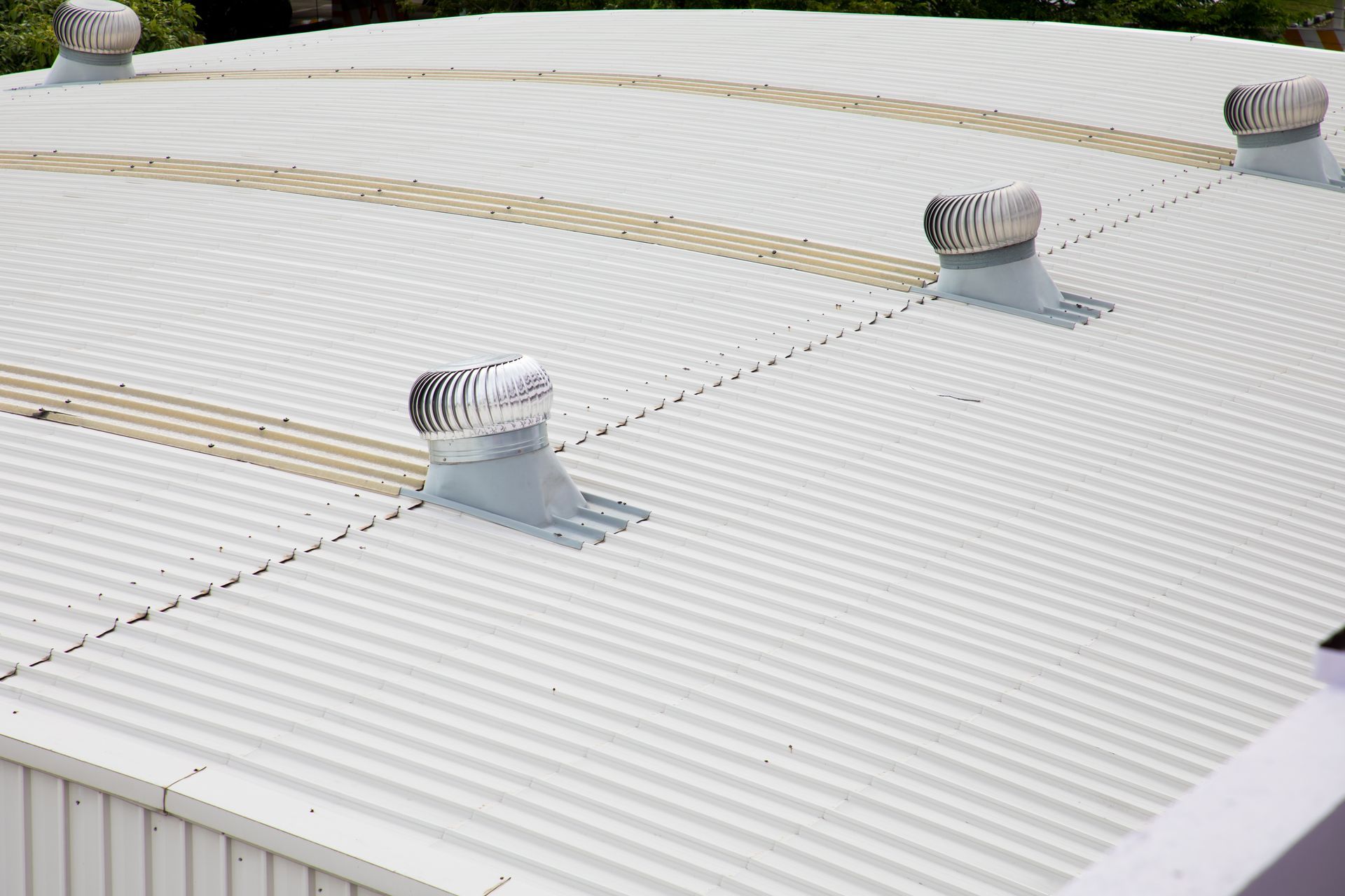 Toiture en tôle ondulée blanche avec plusieurs petites ouvertures de ventilation et lignes de sécurité beiges