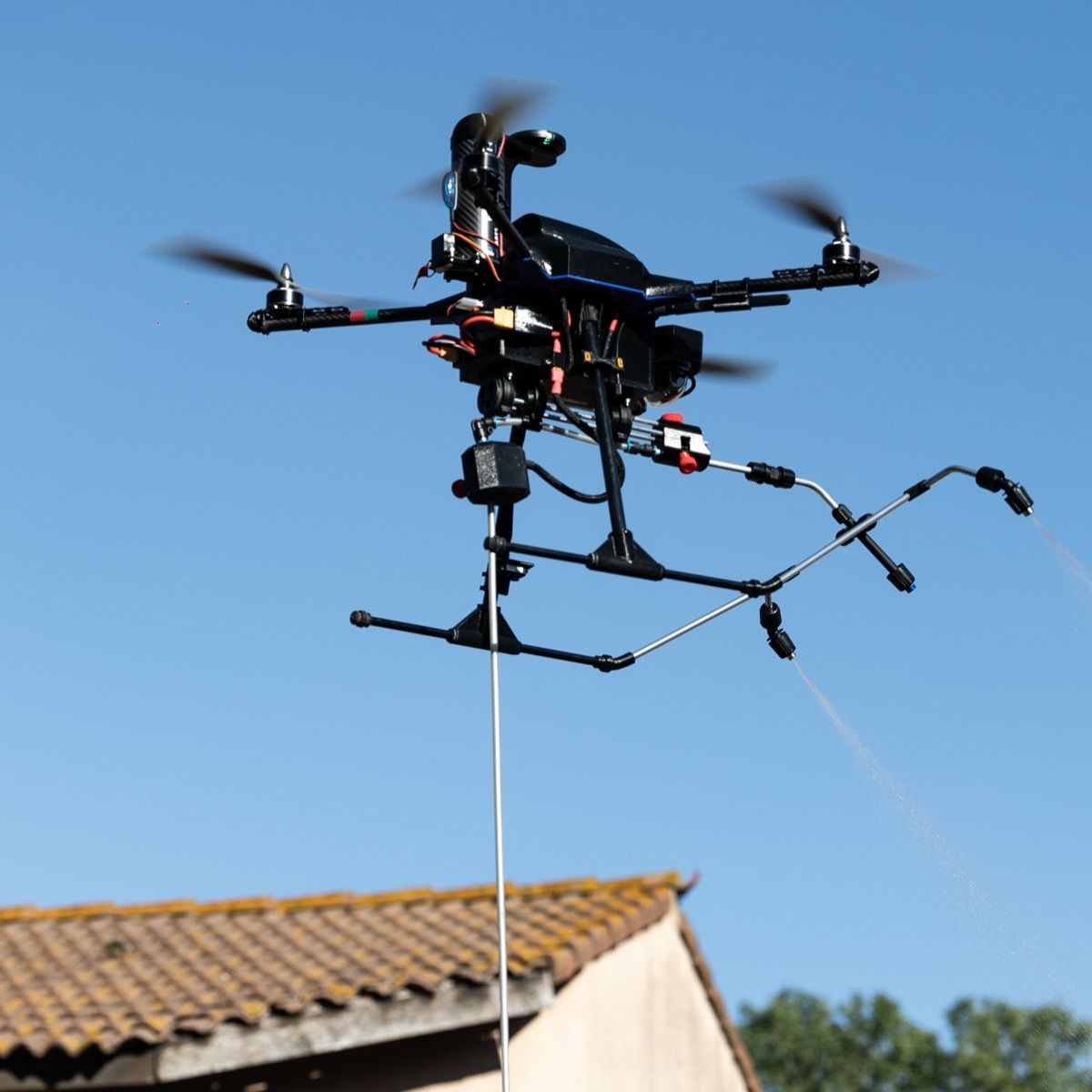 Drone en vol, pulvérisant un produit nettoyant.