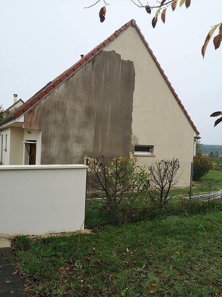 Rangée de maisons en pierre avec des fleurs devant ; journée ensoleillée.