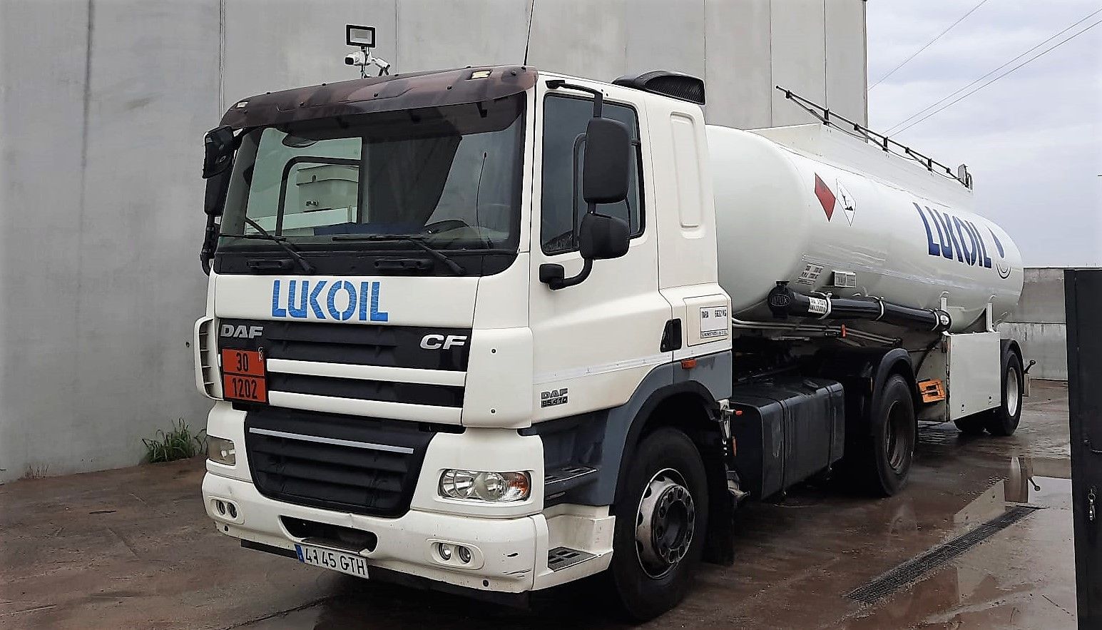 Un camión blanco está estacionado frente a un edificio.