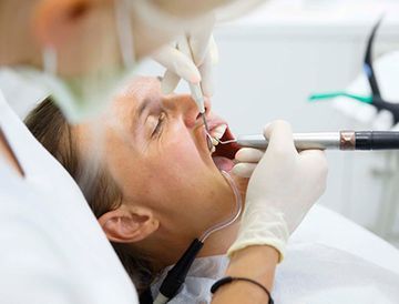 Una mujer está siendo examinada por un dentista.