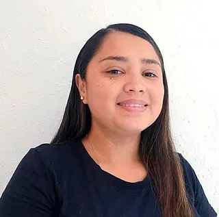 Una mujer con una camisa negra sonríe a la cámara.