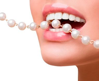 Una mujer lleva un collar de perlas en la boca.