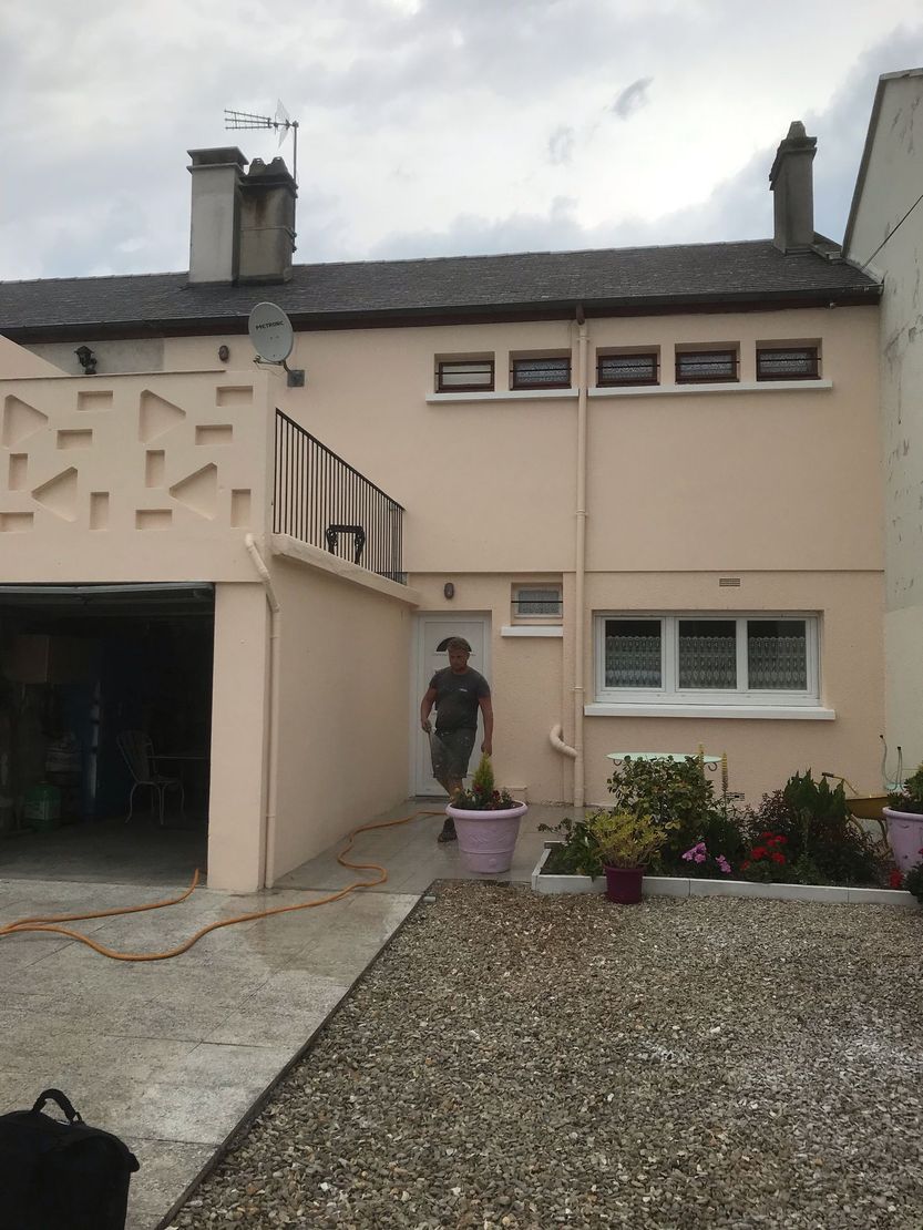 Extérieur de la maison avec une personne debout près de l'entrée principale et de l'allée de gravier.