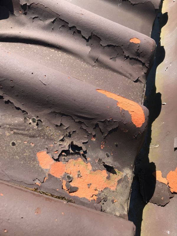 Gros plan sur une surface ondulée grise endommagée.