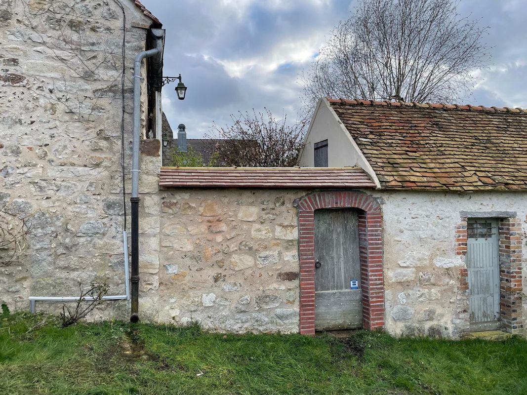 De vieilles maisons en pierre aux portes en bois patinées et au toit de tuiles.