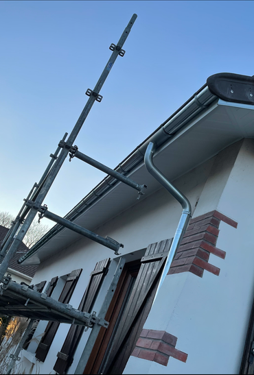 Poteaux d'échafaudage le long de la ligne de toit d'une maison.