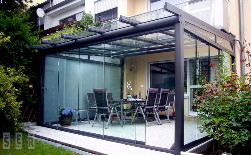 Glashaus mit Ganzglas-Schiebeelemente und Dachüberstand