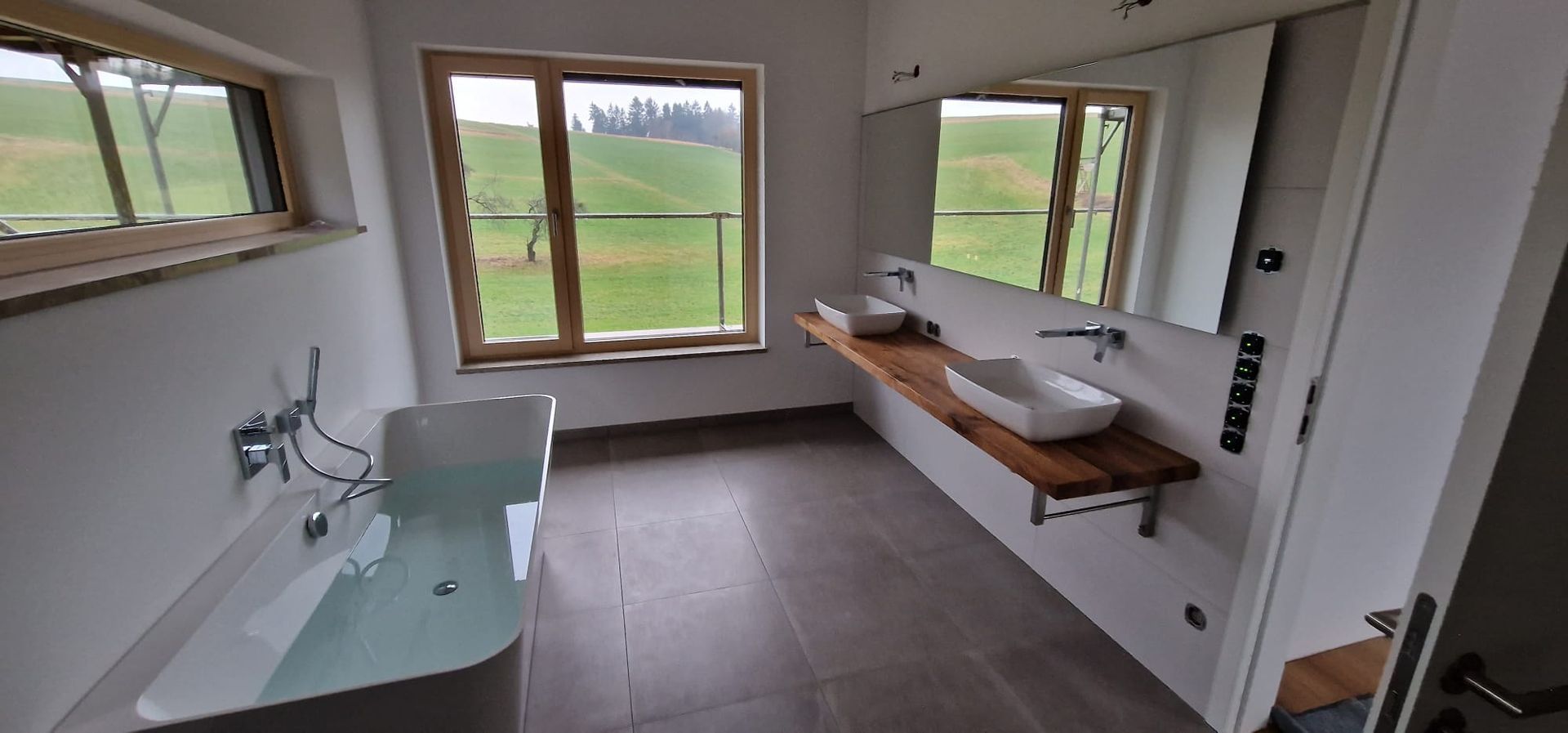 Badezimmer mit großen Fenstern aus Holz