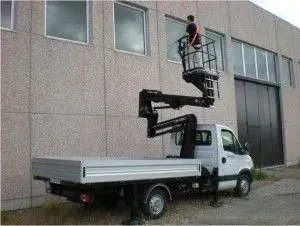 Un homme sur une plate-forme élévatrice lave les vitres d'une nacelle élévatrice montée sur camion