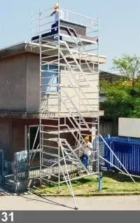 Des ouvriers du bâtiment sur un échafaudage en aluminium à côté d'un bâtiment.