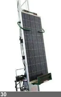 Panneau solaire sur un ascenseur. Le panneau est noir et argent, l'ascenseur est gris et vert.