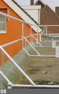 Garde-corps de sécurité sur un toit plat avec un bâtiment en arrière-plan marron et orange.