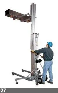 Un homme portant un casque bleu utilise un élévateur pour élever du matériel. Ascenseur gris et métallique.