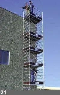 Échafaudage avec des personnes à différents niveaux, adjacent à un bâtiment.