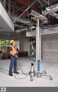 Un ouvrier du bâtiment utilise un ascenseur dans un immeuble. L'ascenseur est équipé d'une plateforme en bois.