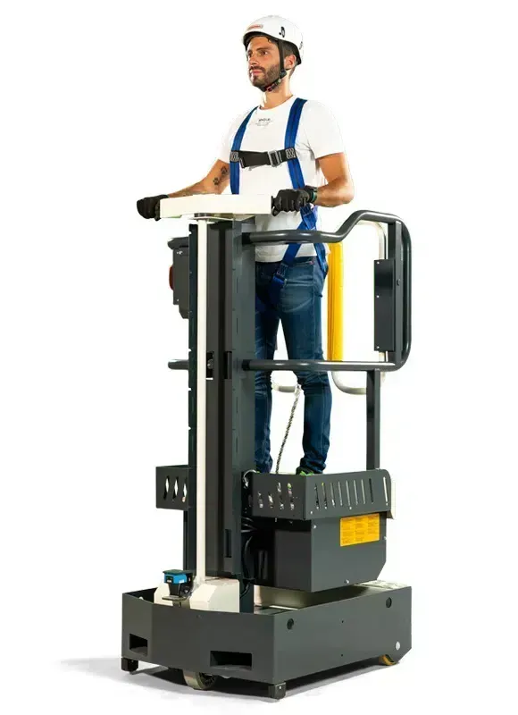 Un homme dans un ascenseur portant un équipement de sécurité, utilisant un équipement dans un environnement blanc.