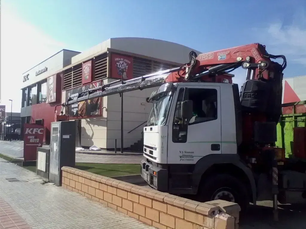 Un camión grúa está estacionado frente a un restaurante KFC.