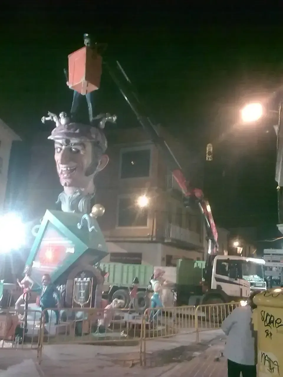 Se está construyendo una gran estatua de un hombre por la noche.