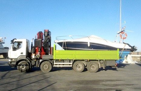 Un camión transporta un barco en la parte trasera.