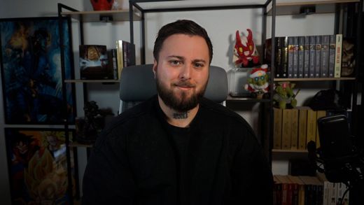 Menschen sitzen um einen Tisch herum und führen unter einer Hängelampe ein Brainstorming mit Laptops und Papier durch.