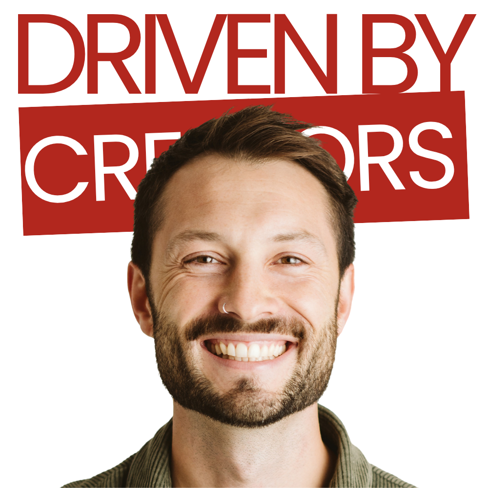 Menschen sitzen um einen Tisch herum und führen unter einer Hängelampe ein Brainstorming mit Laptops und Papier durch.