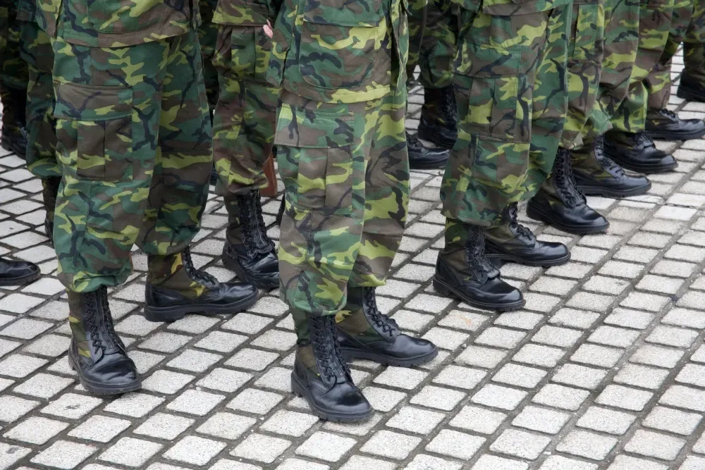 Un grupo de soldados está parado en fila en una acera de ladrillos.