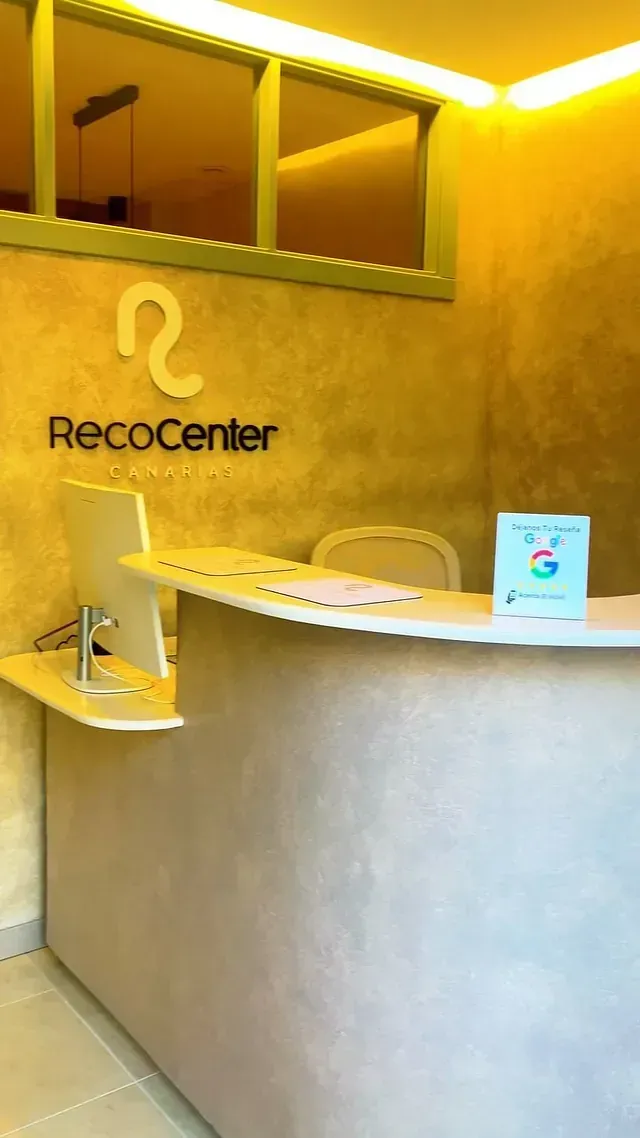 Un mostrador de recepción con una computadora y un cartel que dice recocenter.