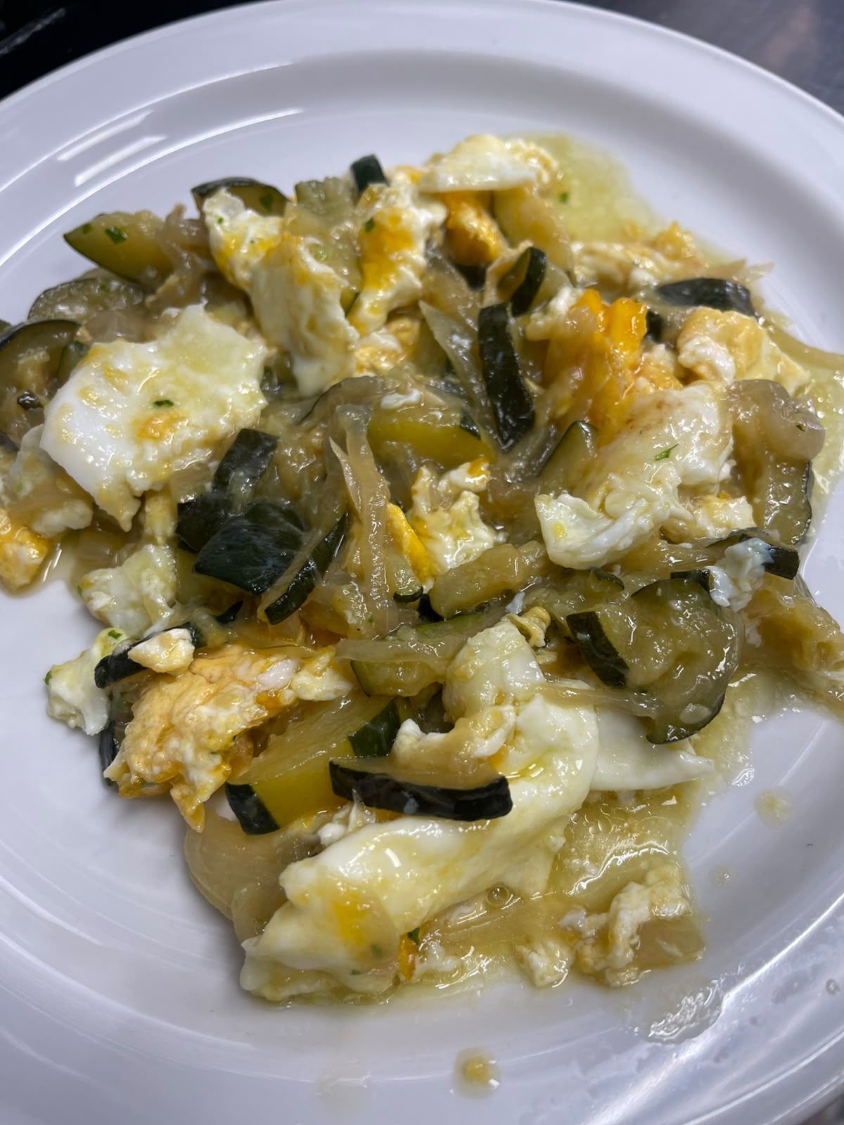 Un plato de verduras variadas cremosas, con trozos amarillos y verdes.