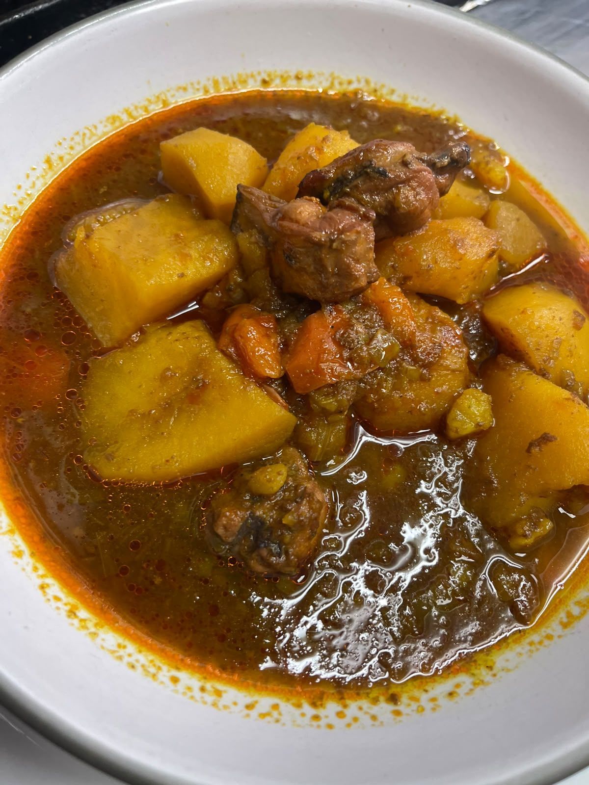 Cuenco de guiso contundente con patatas y carne en un caldo marrón