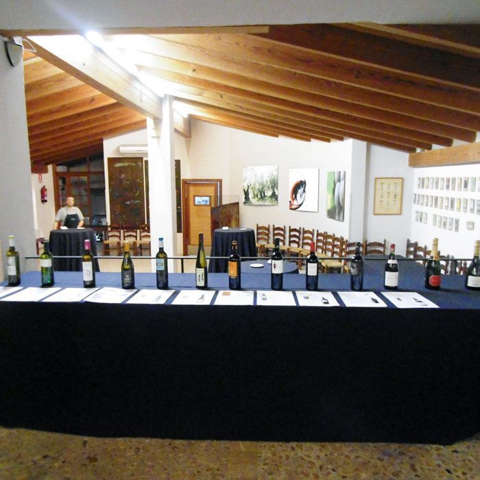 Varias botellas de vino están alineadas sobre una mesa.