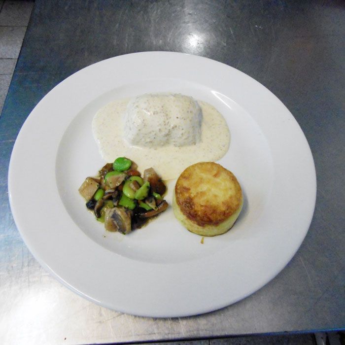 Un plato de comida sobre una mesa de acero inoxidable.