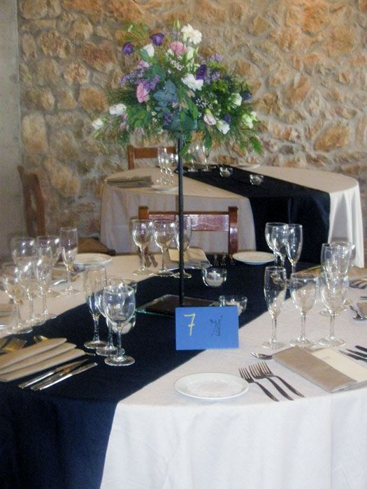 Una mesa preparada para una recepción de boda con el número 7 en ella.