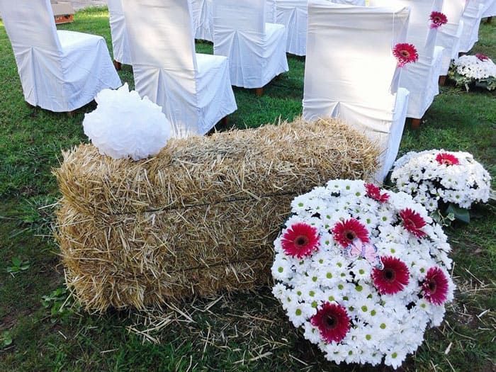 Un montón de fardos de heno con flores en ellos.
