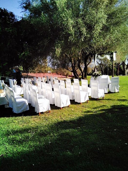 Una fila de sillas blancas en un campo de hierba.