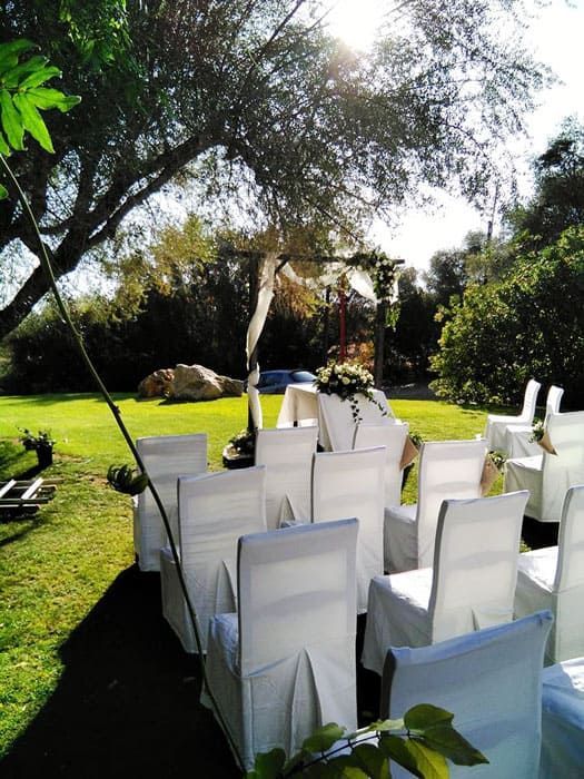 Una fila de sillas blancas están dispuestas para una ceremonia de boda.