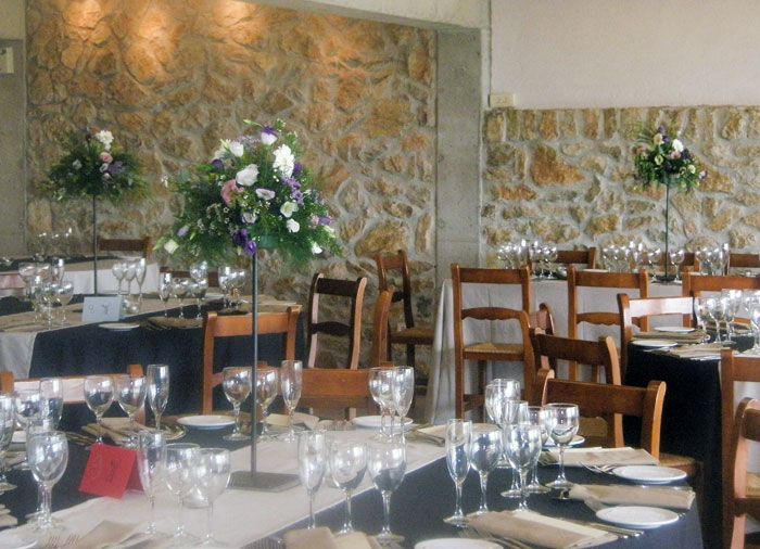 Un comedor con mesas y sillas preparadas para una recepción de boda.