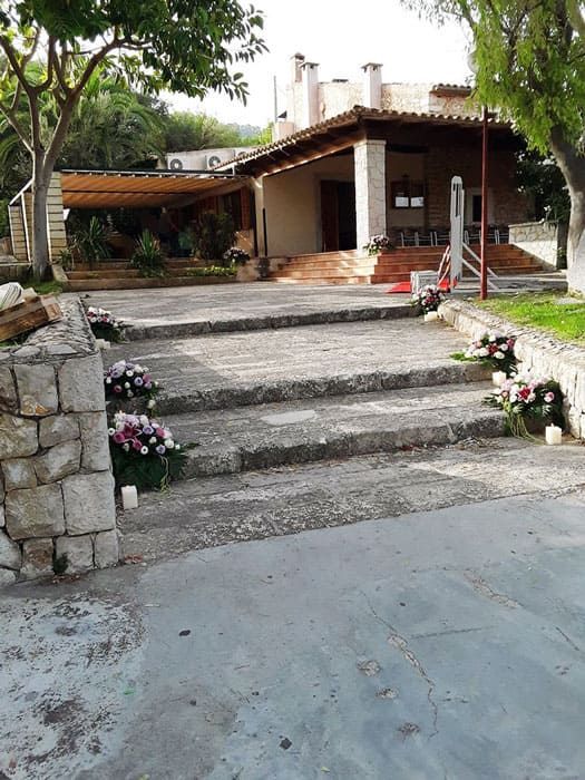 Una casa con escaleras que conducen a ella y flores delante de ella.