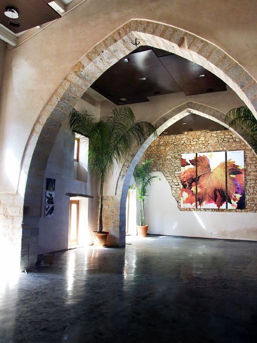 Una habitación con arcos y una pintura en la pared.