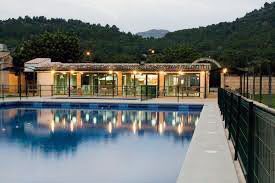 Una gran piscina está rodeada por una valla y un edificio.