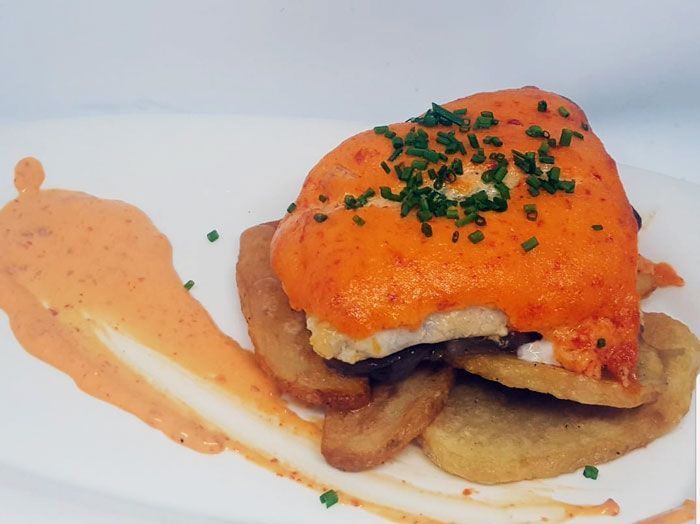 Un primer plano de un plato de comida con salsa encima.