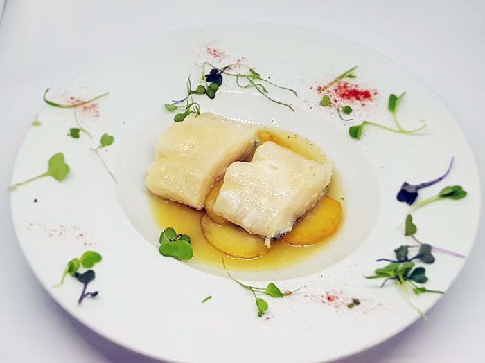 Un plato blanco con un trozo de comida encima.
