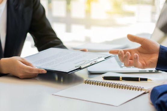 Hände zweier Personen bei einer Beratung am Schreibtisch